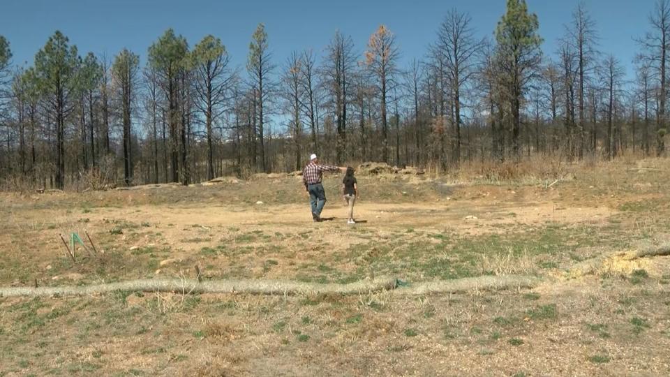 <em>Toby Dolan showing reporter Gabrielle Burkhart where his home used to stand before the Hermits Peak Calf Canyon Wildfire burned it to the ground. </em>