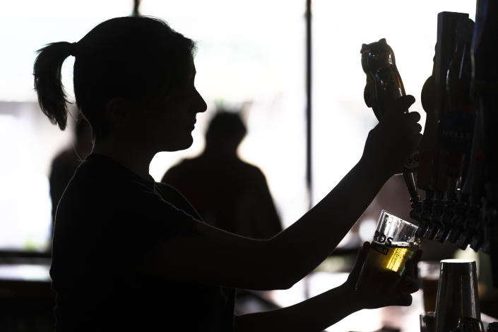 FILE - A bartender pours a beer McMenamin's Tavern in Philadelphia, Thursday, Feb. 9, 2023. A strong job market has helped fuel the inflation pressures that have led the Federal Reserve to keep raising interest rates. (AP Photo/Matt Rourke, File)