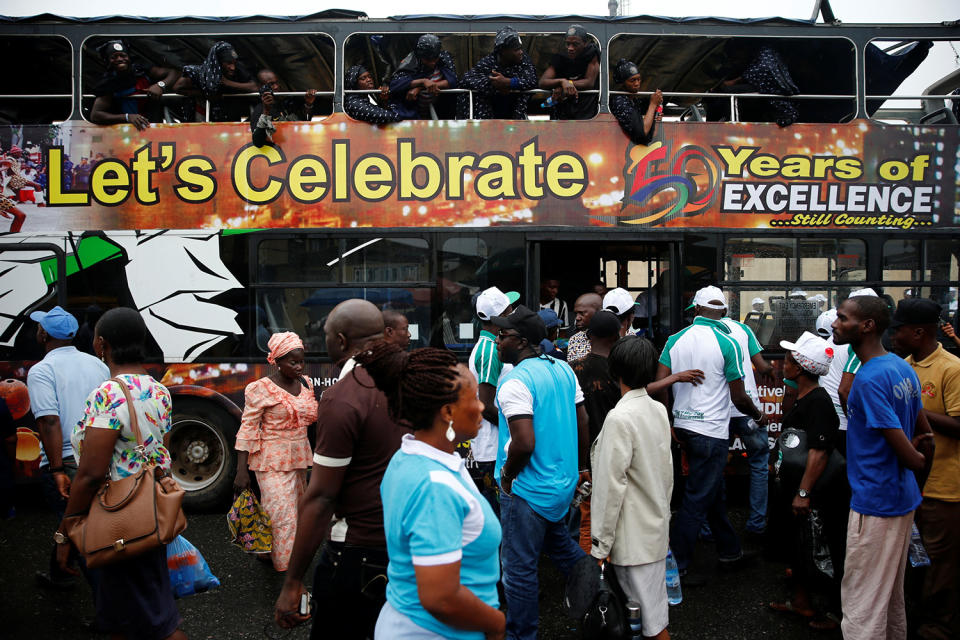 People walking past bus with sign