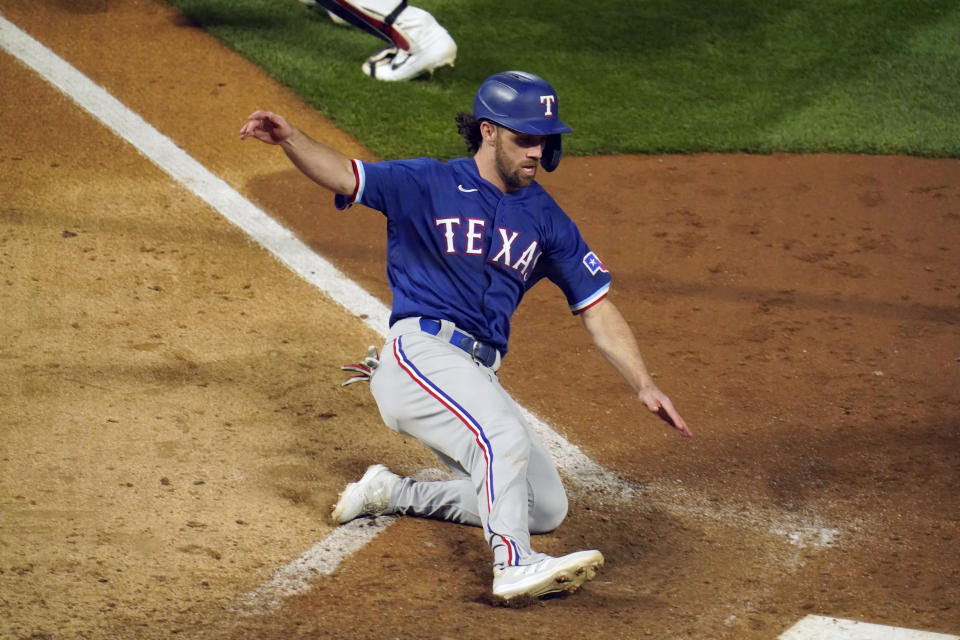 Texas Rangers' Charlie Culberson slides home to tie the score on a sacrifice fly ball by Isiah Kiner-Falefa in the ninth inning of a baseball game, Tuesday, May 4, 2021, in Minneapolis. (AP Photo/Jim Mone)