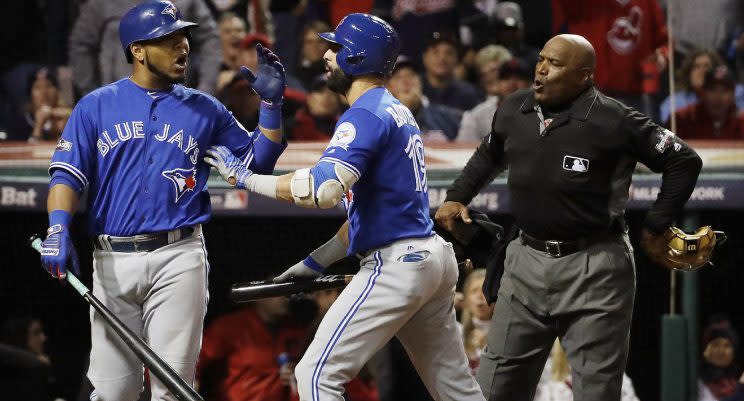 Toronto Blue Jays' Jose Bautista, center, pushes Edwin Encarnacion away from home plate umpire Laz Diaz after Encarnacion was called out on strikes during the eighth inning in Game 1 of baseball's American League Championship Series against the Cleveland Indians in Cleveland, Friday, Oct. 14, 2016. (AP Photo/Matt Slocum)