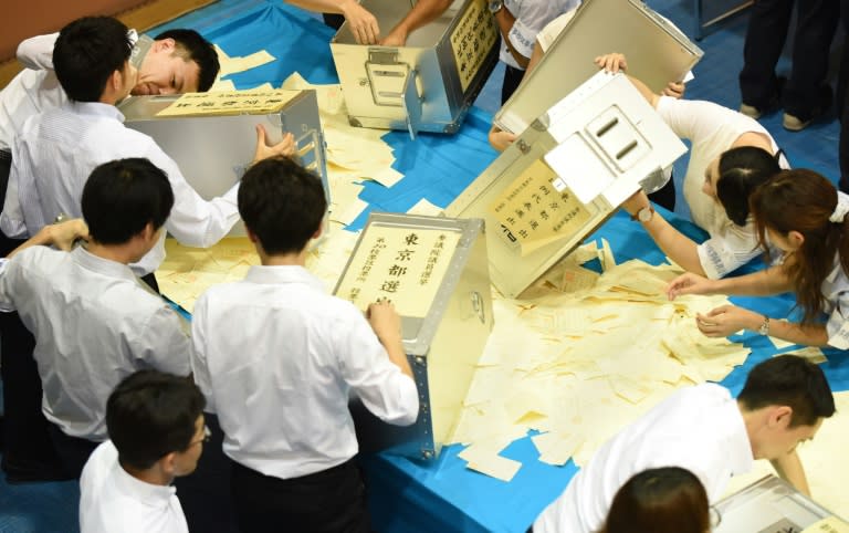 Officials open ballot boxes to count votes cast for Japan's upper house election at an electoral office in Tokyo