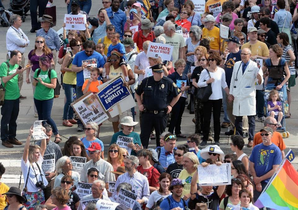 FILE - In this Monday, April 25, 2016, file photo, protesters head into the Legislative building for a sit-in against House Bill 2 in Raleigh, N.C. North Carolina legislators will repeal the contentious HB2 law that limited protections for LGBT people and led to an economic backlash, the state's Gov.-elect Roy Cooper said Monday, Dec. 19, 2016. (Chuck Liddy/The News & Observer via AP, File)