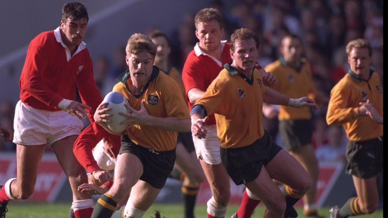 Australia centre Tim Horan breaks through the Wales defence