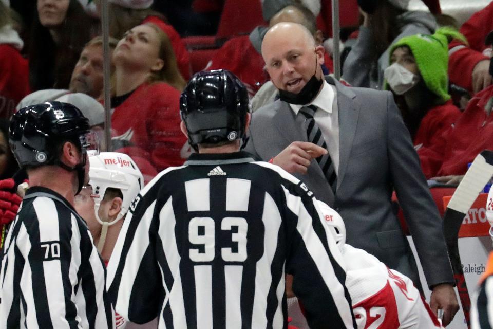 Detroit Red Wings head coach Jeff Blashill, right, discusses a call with the officials during the first period  at PNC Arena in Raleigh, North Carolina, on Dec. 16, 2021.