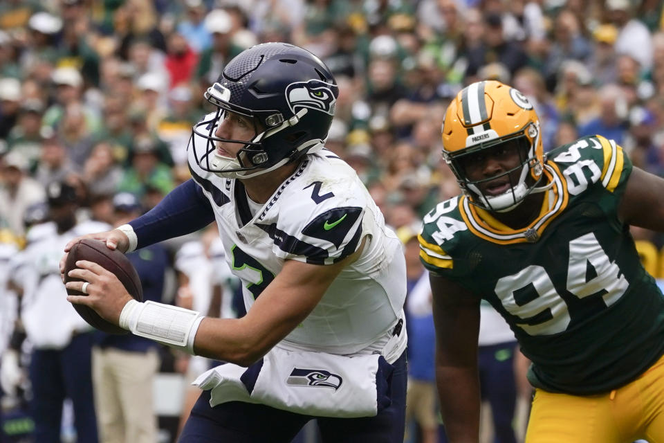 Seattle Seahawks quarterback Drew Lock (2) runs from Green Bay Packers defensive end Karl Brooks (94) in the second half of a preseason NFL football game, Saturday, Aug. 26, 2023, in Green Bay, Wis. (AP Photo/Kiichiro Sato)