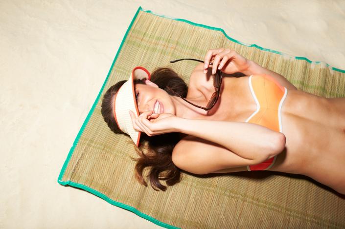 A young woman tanning on the beach