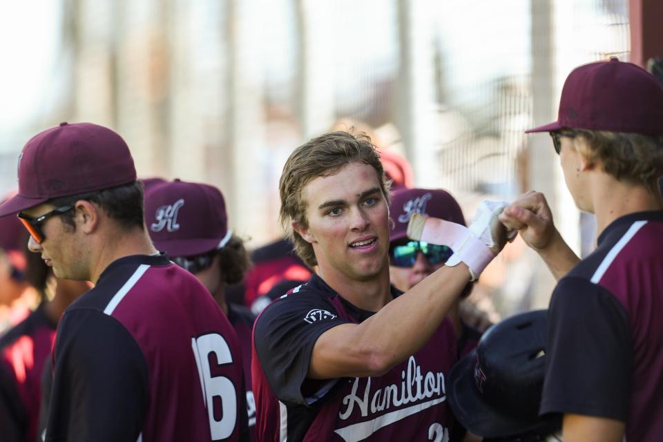 Hamilton's Gavin Turley (24), center, celebrates with teammates after running past home plate and scoring against Brophy College Preparatory at Hamilton High School on Wednesday, April 13, 2022, in Chandler.