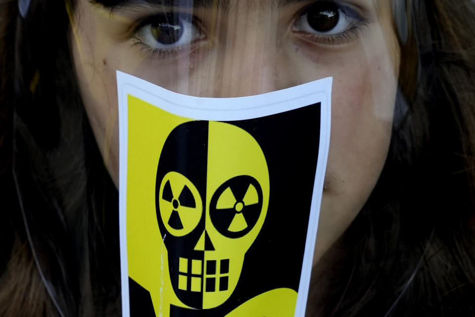 A girl with an anti-nuclear sticker on a mask is seen during a demonstration as Greek Cypriot and Turkish Cypriot activists voice their unease over the ongoing construction of the Russian-owned Akkuyu nuclear power plant in southern Turkey, some 60 miles (100 km) from the island nation's northern coastline, inside the United Nations controlled buffer zone that cuts across the capital Nicosia, Cyprus, on Wednesday, April 27, 2022. Activists say uncertainty over the safety of war-wracked Ukraine's nuclear power plants has re-ignited concerns over a Russian-owned nuclear power plant that's currently being built in a quake-prone area on Turkey's southern coastline. (AP Photo/Petros Karadjias)