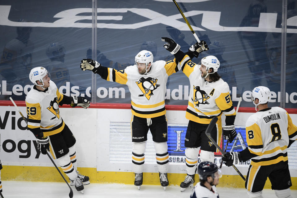 Pittsburgh Penguins right wing Bryan Rust (17) celebrates his goal with left wing Jake Guentzel (59), defenseman Kris Letang (58) and defenseman Brian Dumoulin (8) during the second period of the team's NHL hockey game against the Washington Capitals, Saturday, May 1, 2021, in Washington. (AP Photo/Nick Wass)