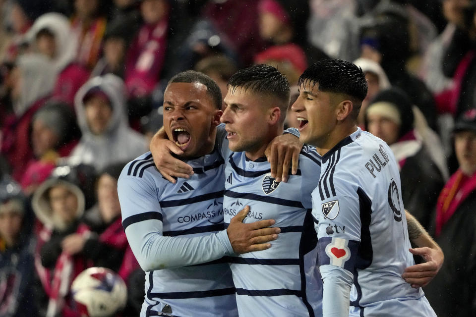 Sporting Kansas City defender Logan Ndenbe, left, midfielder Rémi Walter, center, and forward Alán Pulido celebrate a goal by Walter during the first half of an MLS playoff soccer match against St. Louis City Sunday, Oct. 29, 2023, in St. Louis. (AP Photo/Jeff Roberson)