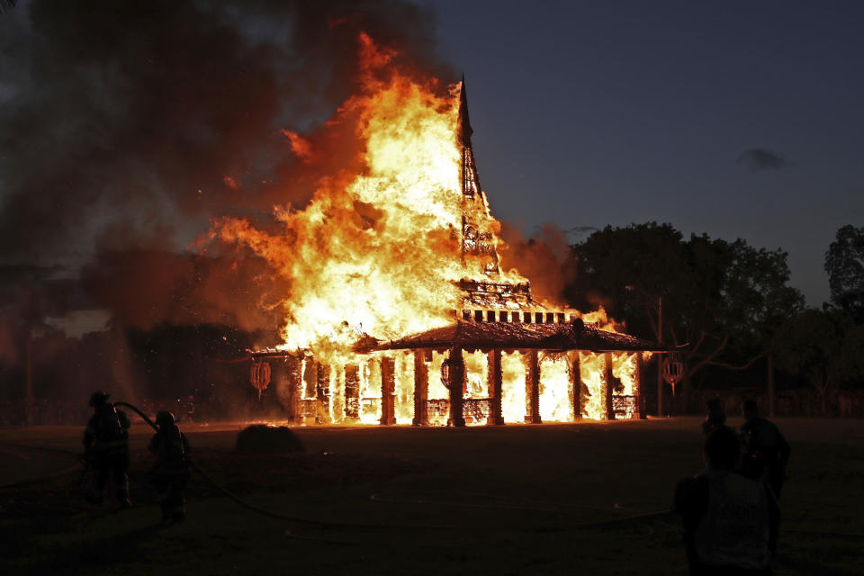 The "Temple of Time" built as a memorial to the 17 victims of a shooting at Marjory Stoneman Douglas High School is seen on fire during a ceremonial burning in Coral Springs, Fla., Sunday, May 19, 2019. The "Temple of Time" public art installation was set on fire Sunday at the ceremony hosted by the cities of Parkland and Coral Springs, where the high school's students live. (John McCall/South Florida Sun-Sentinel via AP)