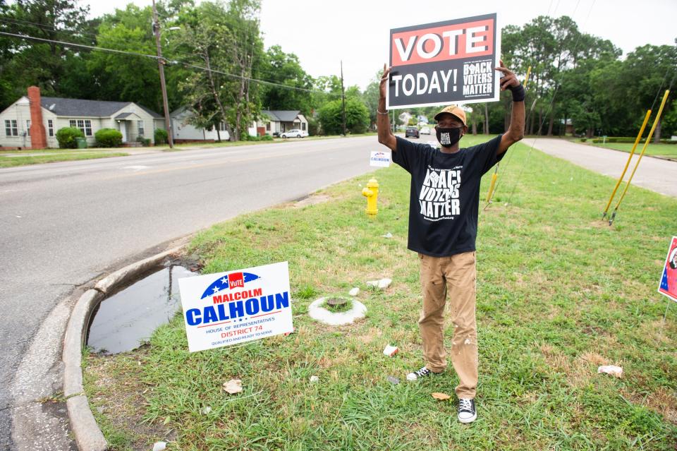 Roderick Calhoun, cousin of candidate Malcom Calhoun, encourages voters near St. Paul AME Church in Montgomery, Ala., on Tuesday, May 24, 2022.