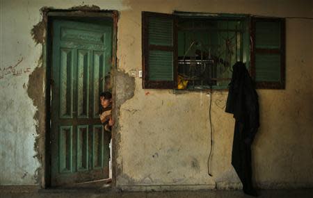 A Palestinian girl looks out from inside her family's house in the northern Gaza Strip March 20, 2014. REUTERS/Mohammed Salem