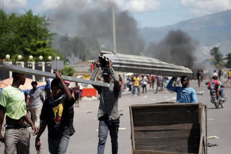 Protesters walk away after looting a police station during demonstration demanding the resignation of Haitian President Jovenel Moise in Port-au-Prince