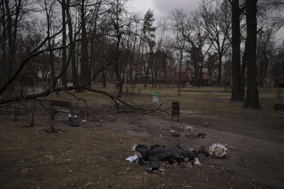 The body of a woman lies at a park in Irpin, on the outskirts of Kyiv, Ukraine, Sunday, March 13, 2022. (AP Photo/Felipe Dana)