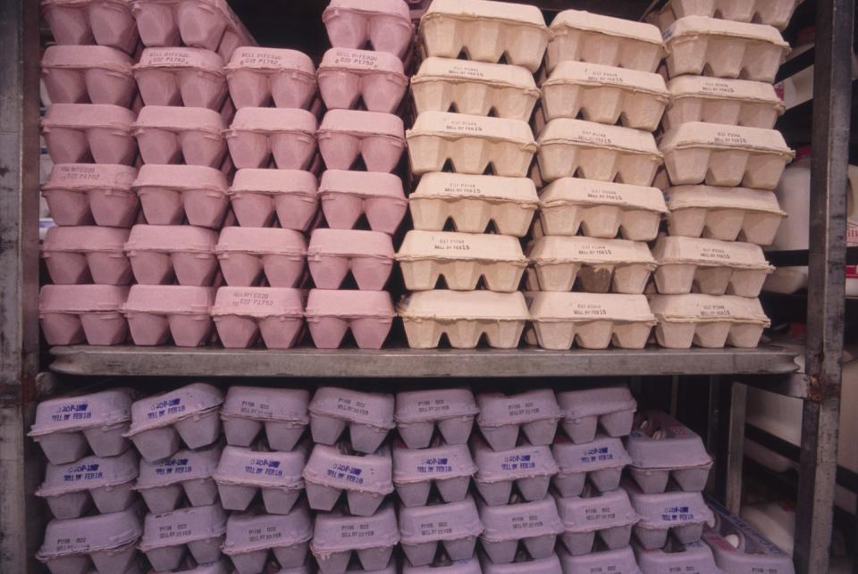 a shelf of egg cartons with expiration dates