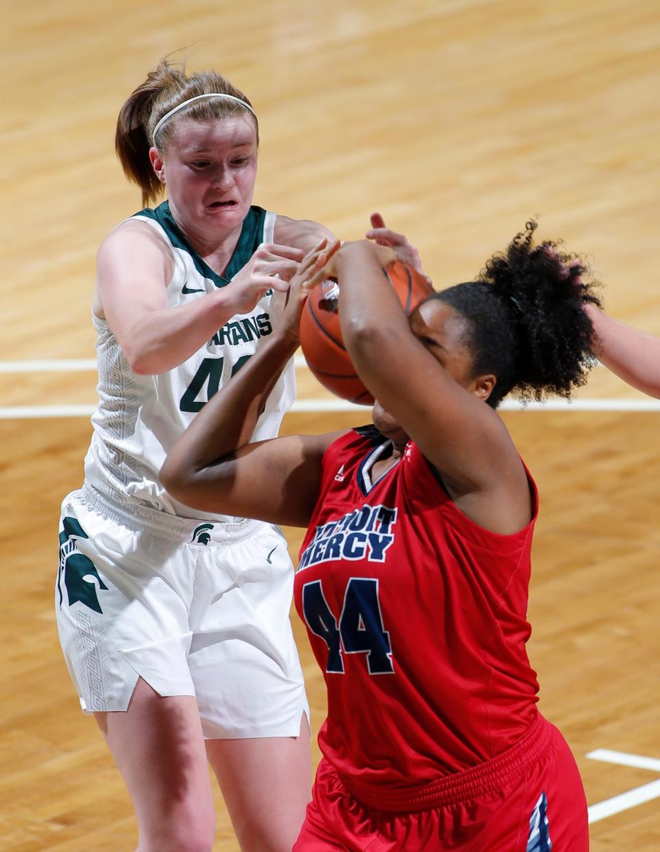 Michigan State's Julia Ayrault, left, and Detroit's Maxine Moore battle for a rebound, Wednesday, Dec. 2, 2020, in East Lansing, Mich. Michigan State won 82-45.