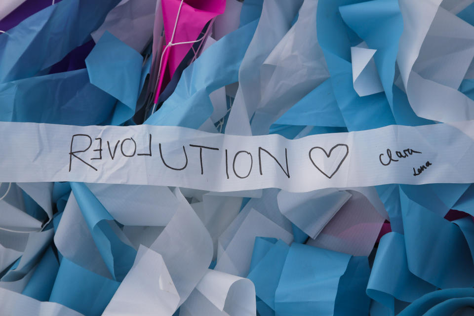 Streamers with written messages as part of the skynet artwork 'Visions In Motion' lay on the ground prior to the setup of the artwork at the 'Strasse des 17. Juni' (Street of June 17) boulevard in front of the Brandenburg Gate in Berlin, Germany, Friday, Nov. 1, 2019. The art work by Patrick Shearn was made with about 100.000 streamers with written messages and is part of the celebrations marking the 30th anniversary of the fall of the Berlin Wall on Nov 9, 2019. (AP Photo/Markus Schreiber)