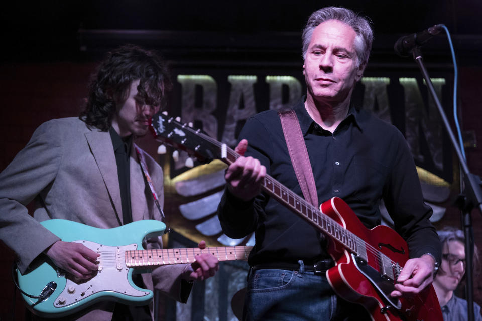 US Secretary of State Antony Blinken performs "Rockin' in the Free World" with members of The 1999 band at the Barman Dictat bar in Kyiv, Tuesday, May 14, 2024. Blinken sought Tuesday to rally the spirits of glum Ukrainians facing a fierce new Russian offensive, assuring them that they are not alone and that billions of dollars in American military aid on its way to the country would make a “real difference” on the battlefield. (Brendan Smialowski/Pool photo via AP)