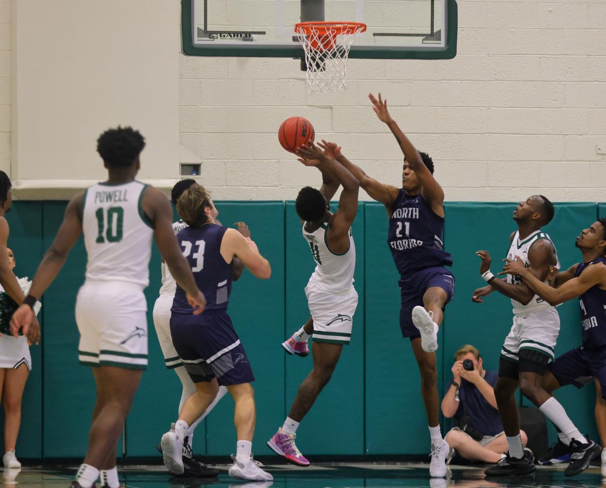 UNF forward Jonathan Aybar (21) tries to block a shot by JU guard Jordan Davis in last year's game at Swisher Gym.