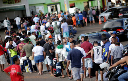 Cars and people line up to fill jerrycans with fuel, due to the truck owners' strike in protest against high diesel prices, in Luziania, Brazil May 27, 2018. REUTERS/Ueslei Marcelino