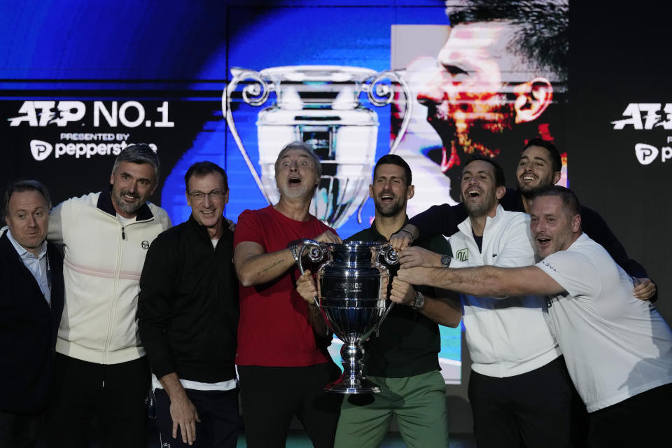Serbia's Novak Djokovic holds the trophy with his team as ATP world best player at the ATP World Tour Finals, at the Pala Alpitour, in Turin, Italy, Monday, Nov. 13, 2023. Djokovic was presented with the trophy for finishing the year ranked No. 1. (AP Photo/Antonio Calanni)