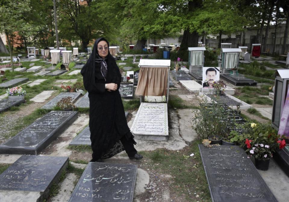 In this picture taken on Monday, April 28, 2014, Iranian woman Samereh Alinejad leaves a cemetery after praying at the grave of her sons Amir Hossein and Abdollah in the city of Royan about 146 miles (235 kilometers) north of the capital Tehran, Iran. Amir Hossein was killed in a motorcycle crash and Abdollah was killed in a street brawl. Alinejad tells The Associated Press that she had felt she could never live with herself if the man who killed her son Abdollah were spared from execution. But in the last moment, she pardoned him in an act that has made her a hero in her hometown, where banners in the streets praise her family’s mercy. (AP Photo/Vahid Salemi)