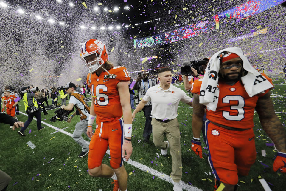 Clemson quarterback Trevor Lawrence, left, leaves the field after a NCAA College Football Playoff national championship game against LSU, Monday, Jan. 13, 2020, in New Orleans. LSU won 42-25.(AP Photo/Gerald Herbert)