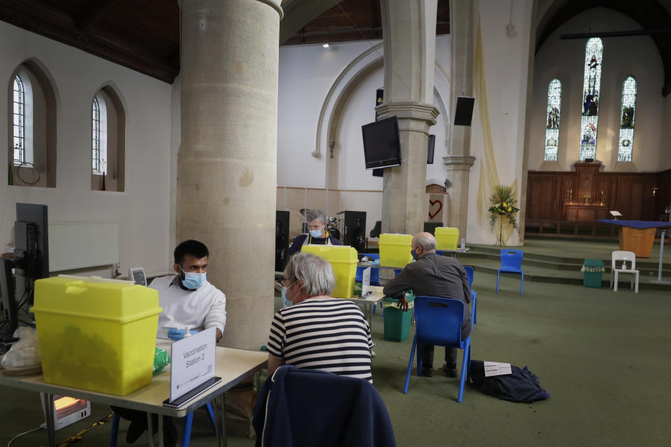 Pharmacist Rajan Shah, left, speaks to a patient before giving the AstraZeneca vaccine at St John's Church, in Ealing, London, Tuesday, March 16, 2021. In recent days, countries including Denmark, Ireland and Thailand have temporarily suspended their use of AstraZeneca's coronavirus vaccine after reports that some people who got a dose developed blood clots, even though there's no evidence that the shot was responsible. The European Medicines Agency and the World Health Organization say the data available do not suggest the vaccine caused the clots.​ Britain and several other countries have stuck with the vaccine. (AP Photo/Kirsty Wigglesworth)