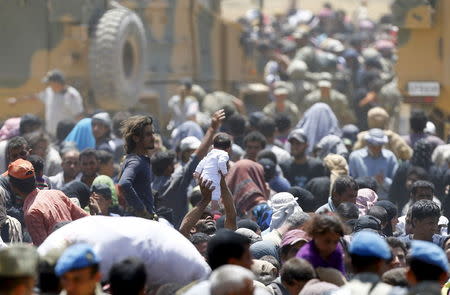 Syrian refugees wait for transportation after crossing into Turkey from the Syrian town of Tal Abyad, near Akcakale in Sanliurfa province, Turkey, June 10, 2015. REUTERS/Osman Orsal