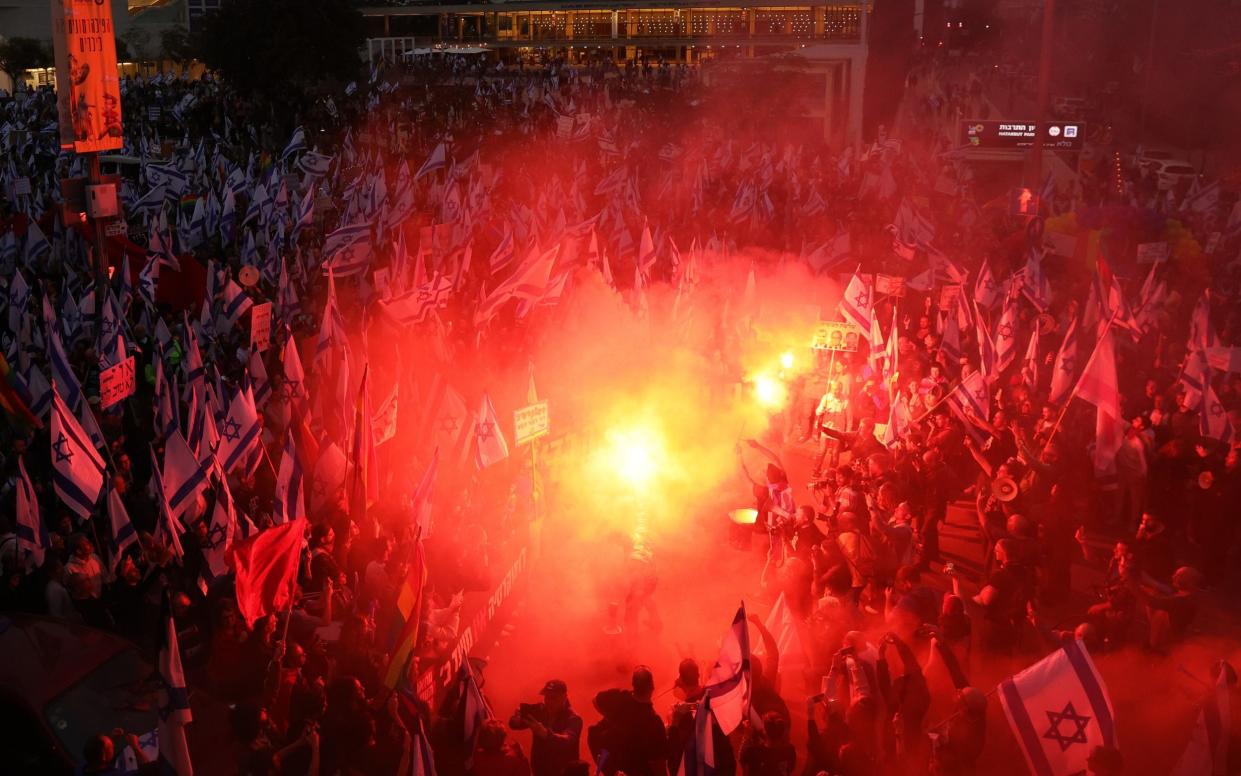  Protesters light flares during a march against government's justice system reform plans in Tel Aviv - ABIR SULTAN/EPA-EFE/Shutterstock/Shutterstock