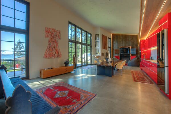 Polished concrete floors run throughout the living spaces, while soaring windows provide unobstructed waterfront views.