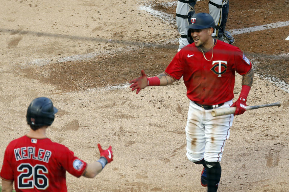 Minnesota Twins' Max Kepler, left, congratulates Ildemaro Vargas after he scored on Ryan Jeffers' RBI single off Milwaukee Brewers pitcher Brandon Woodruff in the third inning of a baseball game Thursday, Aug. 20, 2020, in Minneapolis. (AP Photo/Jim Mone)