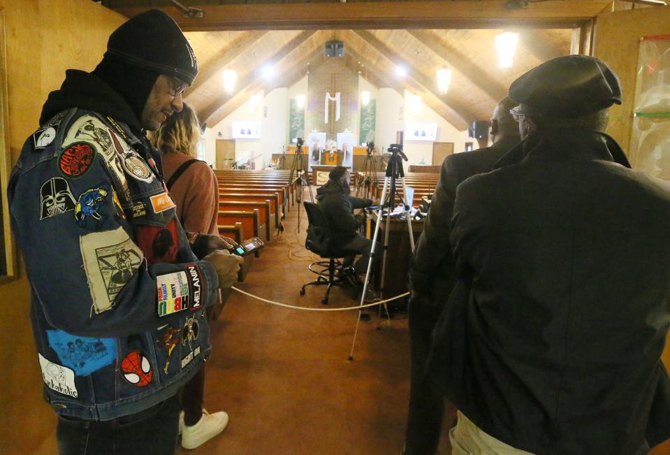 Bruce Butcher of The Freedom BLOC and Akron Prophetic Voices, left,  watches the Ohio attorney general's press conference on the Jayland Walker case at St. Ashworth Temple Church of God in Christ on Monday. Walker's family attends the church.