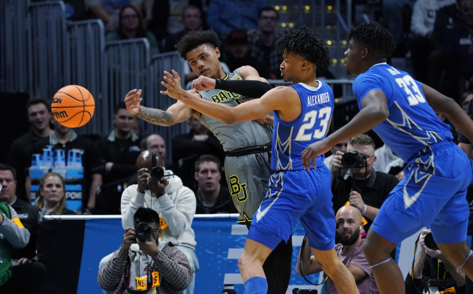 Baylor guard Keyonte George, left, passes the ball as Creighton guard Trey Alexander, center, and center Fredrick King defend in the first half of a second-round college basketball game in the men's NCAA Tournament, Sunday, March 19, 2023, in Denver. (AP Photo/John Leyba)