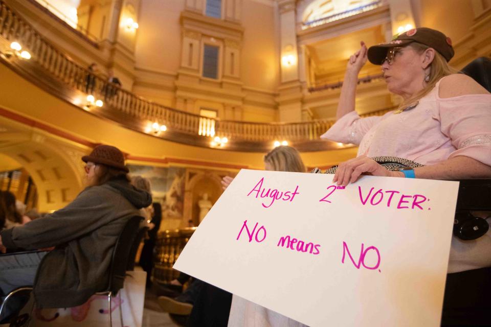 Abortion-rights supporters hold signs during a rally at the Statehouse.
