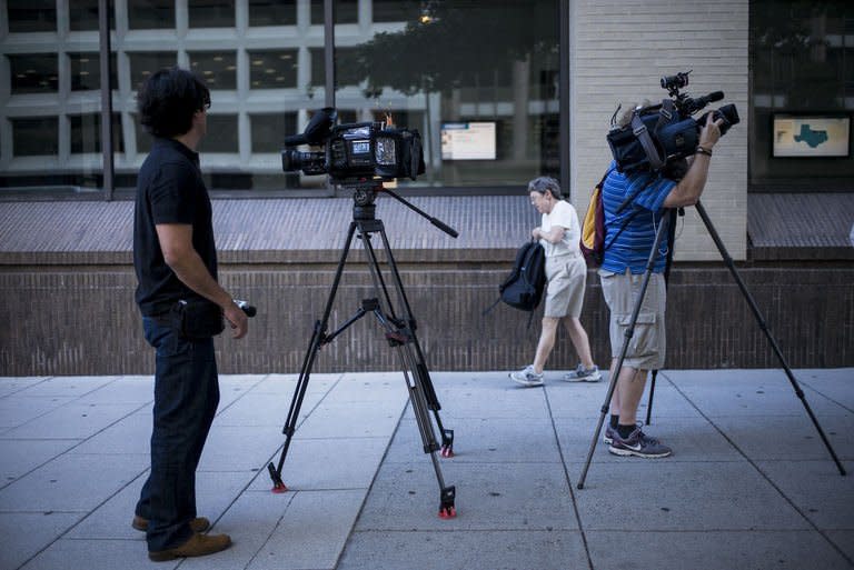 Members of the press wait outside The Washington Post August 5, 2013 in Washington, DC. The Post is best known for its Watergate reporting, in which now legendary journalists Carl Bernstein and Bob Woodward exposed lawbreaking by the White House of Richard Nixon, leading to the president's 1974 resignation