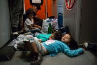 Migrant children sleep on the floor on the train from Budapest to Munich at the Austrian - Hungarian border in Hegyeshalom on August 31, 2015