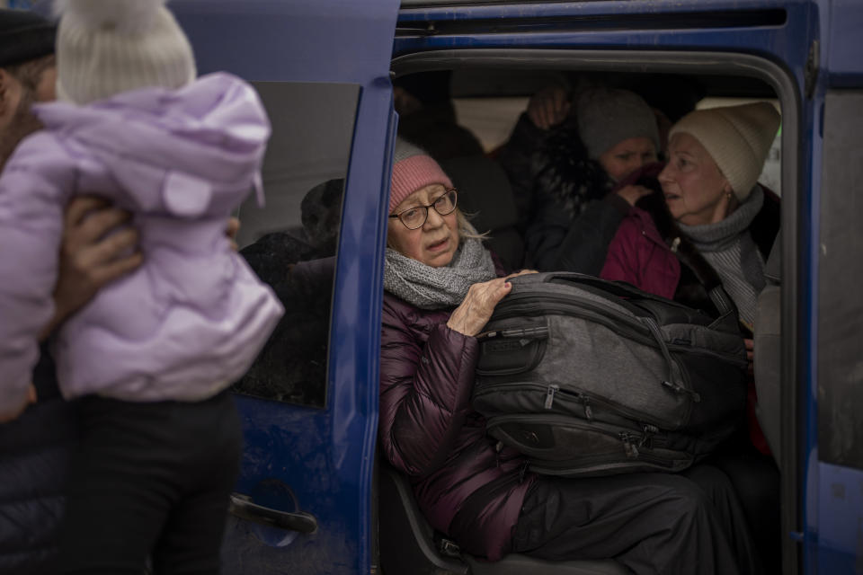 Ukrainian women sit inside a van as artillery echoes nearby, as people flee Irpin on the outskirts of Kyiv, Ukraine, Monday, March 7, 2022. Russia announced yet another cease-fire and a handful of humanitarian corridors to allow civilians to flee Ukraine. Previous such measures have fallen apart and Moscow's armed forces continued to pummel some Ukrainian cities with rockets Monday. (AP Photo/Emilio Morenatti)