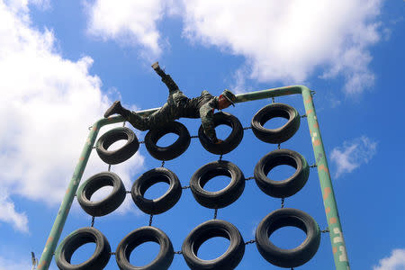 A Chinese paramilitary policeman climbs an obstacle during training in Nanning, Guangxi Zhuang Autonomous Region, China, August 11, 2017. Picture taken August 11, 2017. REUTERS/Stringer