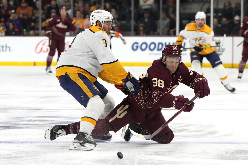 Arizona Coyotes right wing Christian Fischer (36) is checked by Nashville Predators defenseman Jeremy Lauzon while making a pass in the first period during an NHL hockey game, Sunday, Feb. 26, 2023, in Tempe, Ariz. (AP Photo/Rick Scuteri)