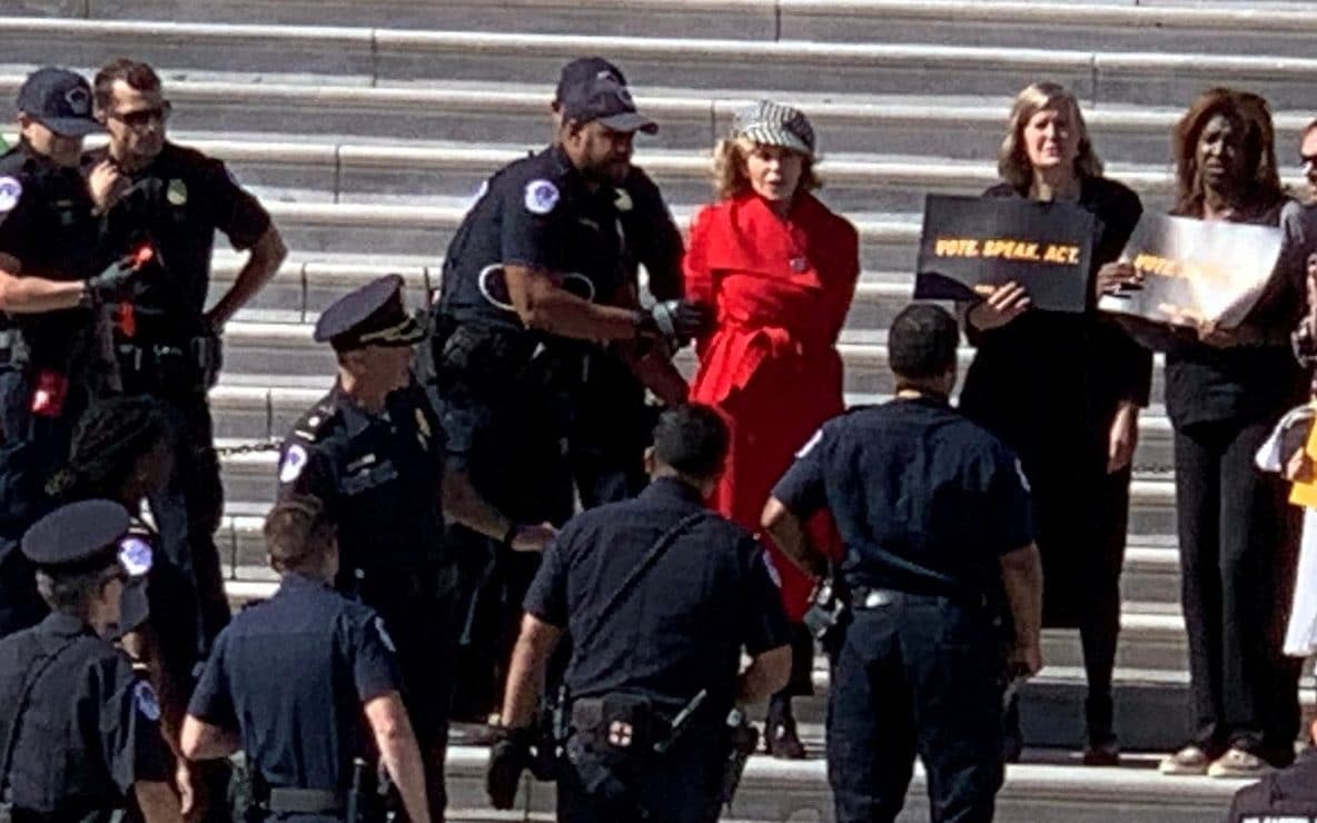 Jane Fonda, in red, was arrested outside the US Capitol - ARLO HEMPHILL via REUTERS