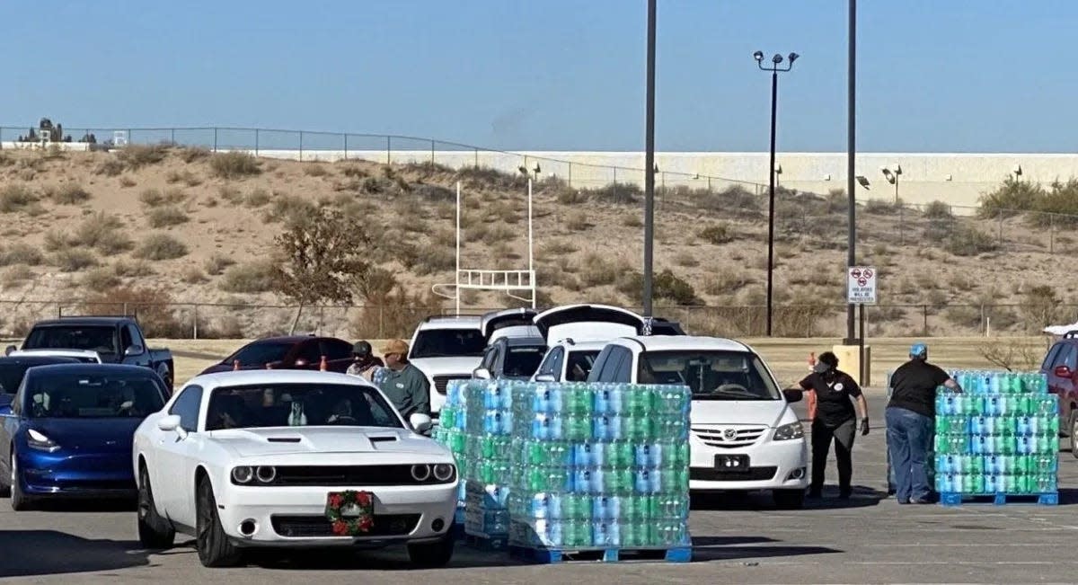 Workers with Dona Ana County distribute cases of water to residents in Santa Teresa and Sunland Park, who spent days without potable water.