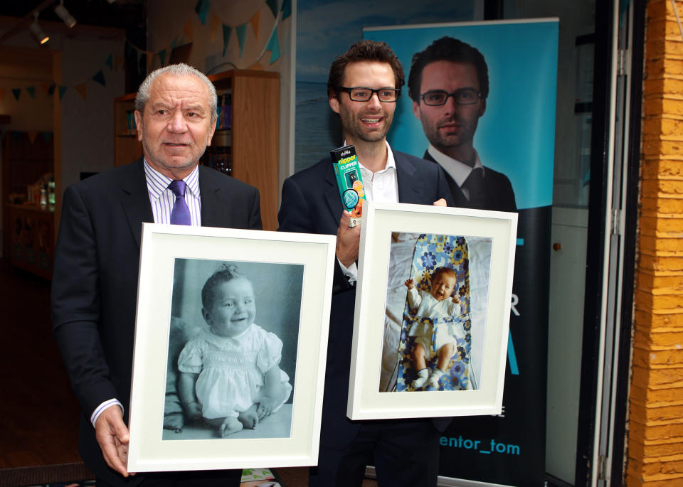 Lord Sugar and inventor Tom Pellereau, who won the 2012 series of The Apprentice, hold pictures of themselves as babies in Convent Garden, London, during the unveiling of their latest product, a nail clipper for children.