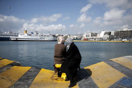 Two stranded migrants sit at a pier at the port of Piraeus, near Athens, Greece, February 26, 2016. REUTERS/Alkis Konstantinidis