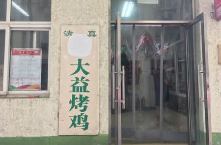 The Arabic script on a halal sign outside a store is seen covered, at Niujie area in Beijing