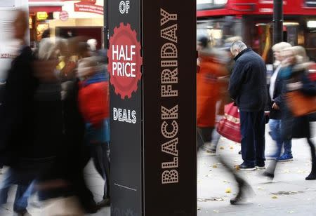 Shoppers walk past the entrance to a store promoting "Black Friday" in Oxford Street, London, Britain November 24, 2016. REUTERS/Peter Nicholls
