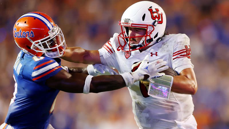 Utah quarterback Cameron Rising, who is questionable for tonight’s opener against Florida, stiff-arms Gators safety Trey Dean III in Gainesville, Fla., on Saturday, Sept. 3, 2022.