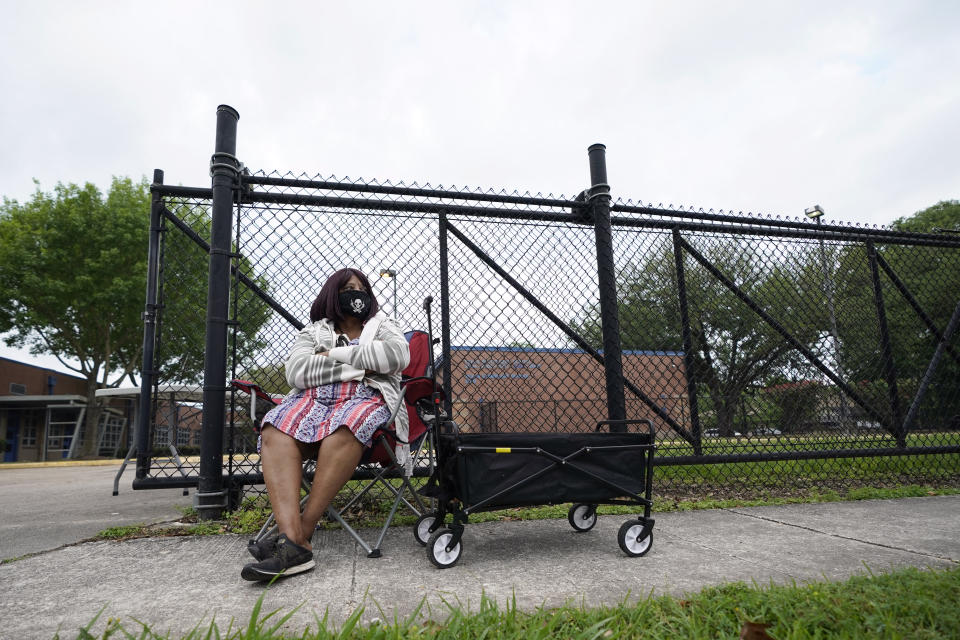 Wanda Williams waits for a Houston Independent School District food distribution site to open Monday, April 6, 2020, in Houston. HISD relaunched their food distribution efforts throughout the district Monday, with a streamlined process that will implement increased safety measures. (AP Photo/David J. Phillip)